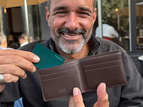 Un homme montre la carte Ponexio sortie de son portefeuille