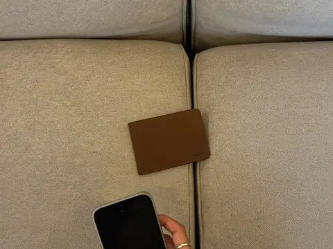 Un portefeuille glissé entre deux coussins de canapé